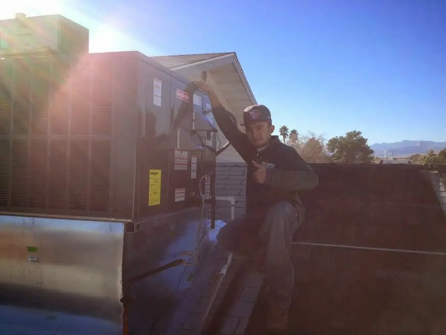 HVAC technician performing Heat Pump Repair on a rooftop unit in Monticello